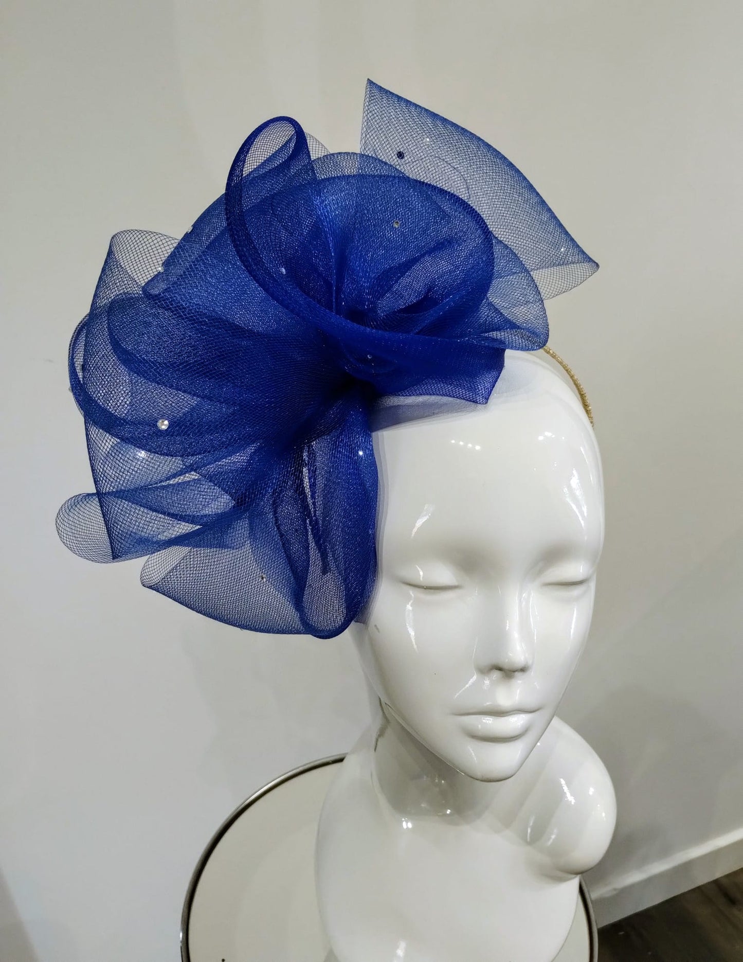 Blue mesh headpiece on a mannequin head against a white background