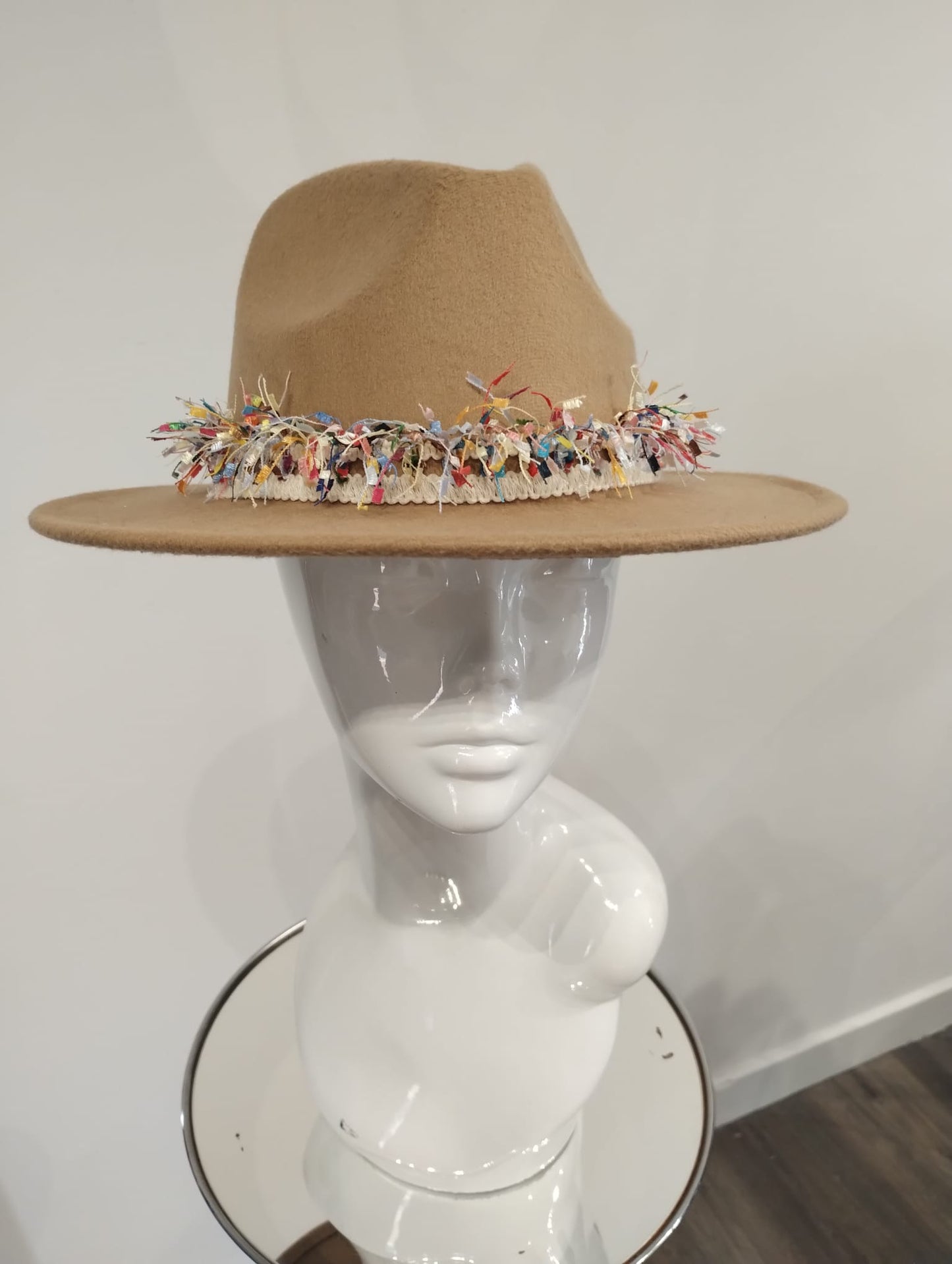 Tan hat with colorful trim on a mannequin head against a white background