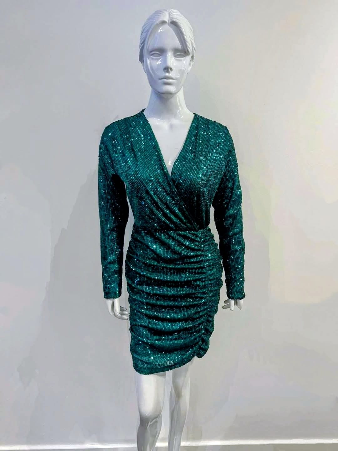 Mannequin wearing a green sequin dress against a plain background


